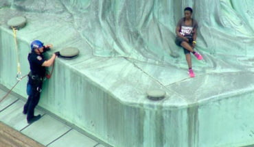 Mujer escala a pedestal de la Estatua de la Libertad; protesta contra política migratoria de EUA
