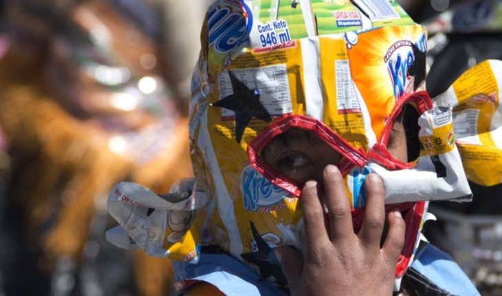 translated from Spanish: Bolivian children dance and recycled plastic in poor city