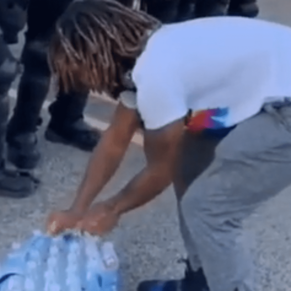 Hombre ofrece agua a policías que combaten las manifestaciones en EU