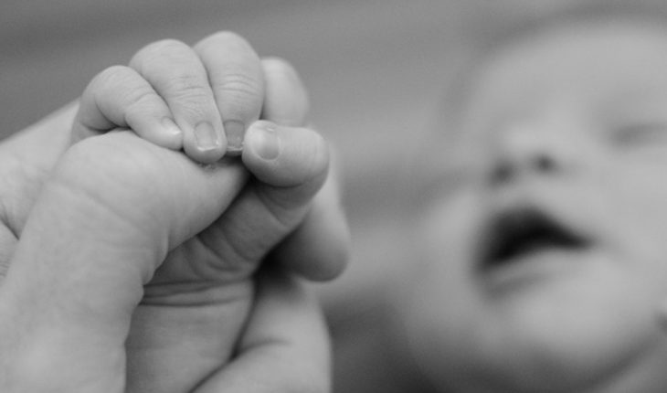Imagen de un bebé recién nacido sosteniendo un DIU se hace viral