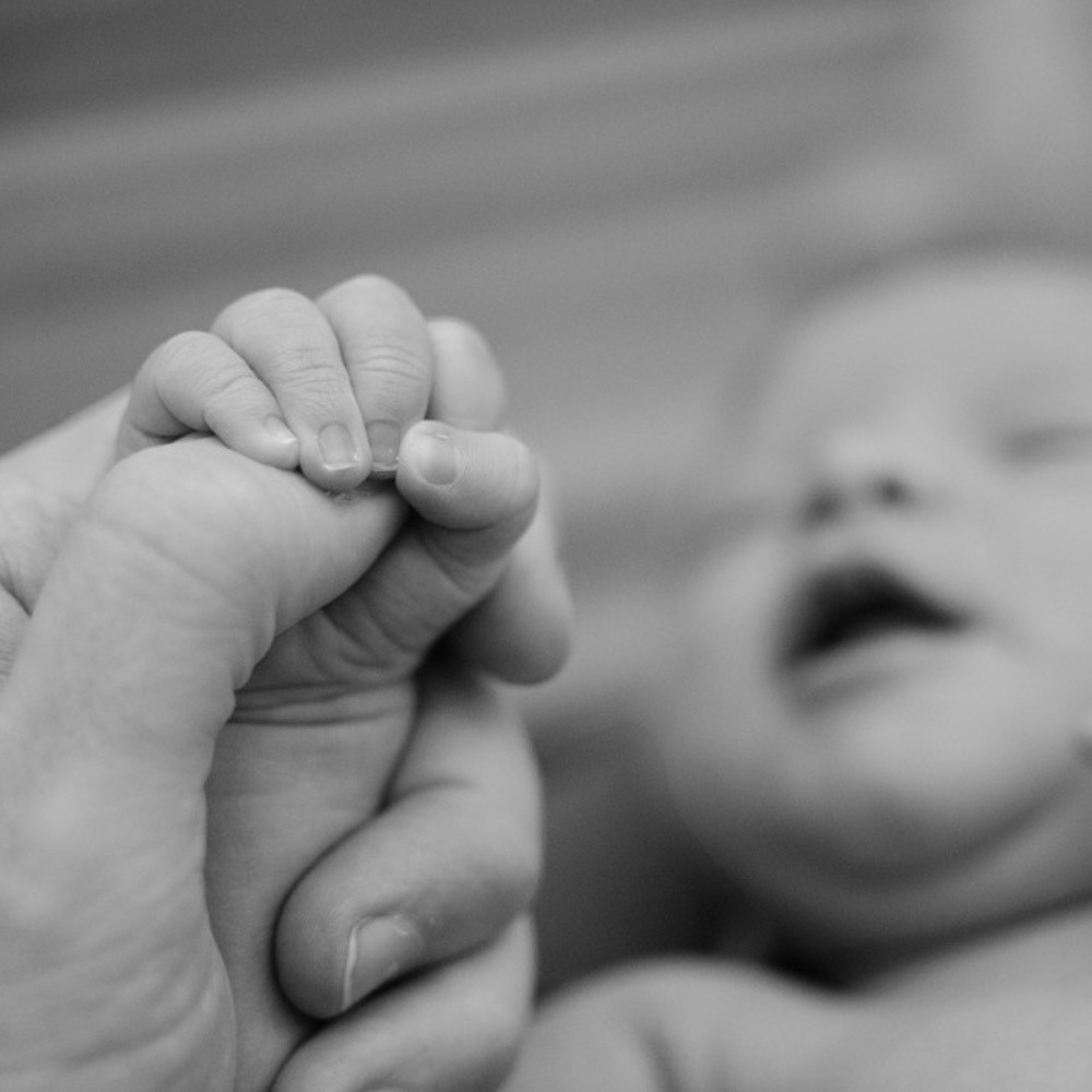Imagen de un bebé recién nacido sosteniendo un DIU se hace viral