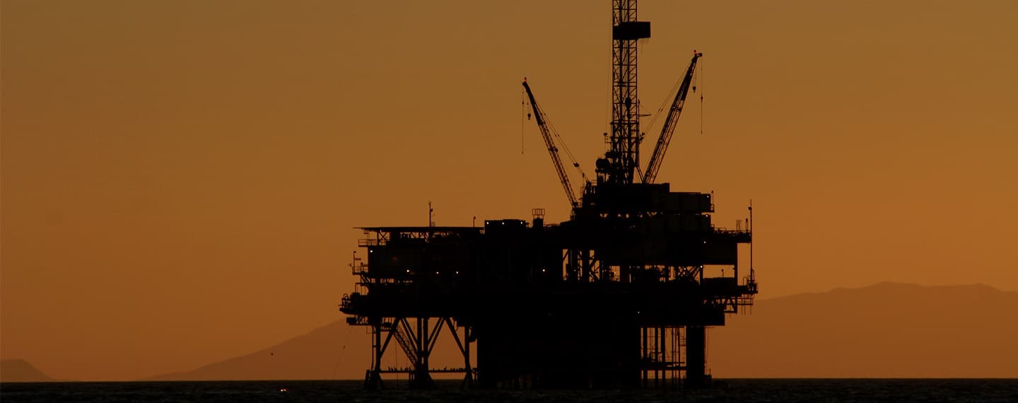 Plataforma petrolífera en alta mar después de la puesta de sol. La isla Catalina es visible en el fondo. Crisis energética europea